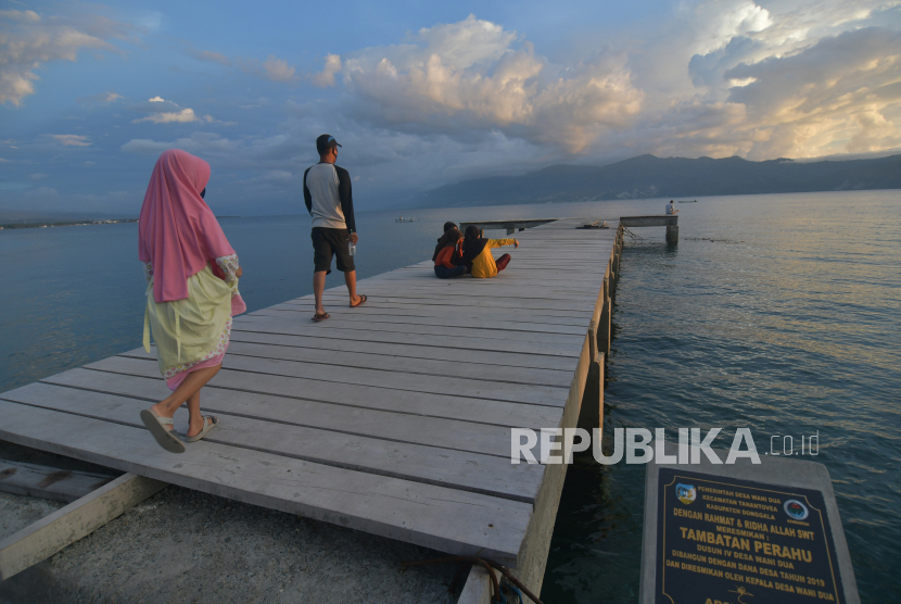 Sejumlah warga menunggu waktu berbuka puasa (ngabuburit) di atas tambatan perahu yang dibangun dengan menggunakan dana desa di Desa Wani, Kabupaten Donggala, Sulawesi Tengah, Selasa (5/5/2020). Pemanfaatan dana desa untuk pembangunan tambatan perahu tersebut diharapkan dapat memudahkan aktivitas dan meningkatkan kesejahteraan masyarakat di desa tersebut yang sebagian besar berprofesi sebagai nelayan