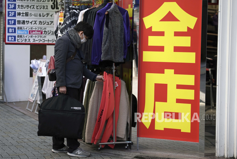 Seorang pria yang mengenakan masker pelindung untuk membantu mengekang penyebaran virus corona melihat-lihat pakaian yang dijual di sebuah toko Senin, Januari. 25, 2021 di Tokyo.