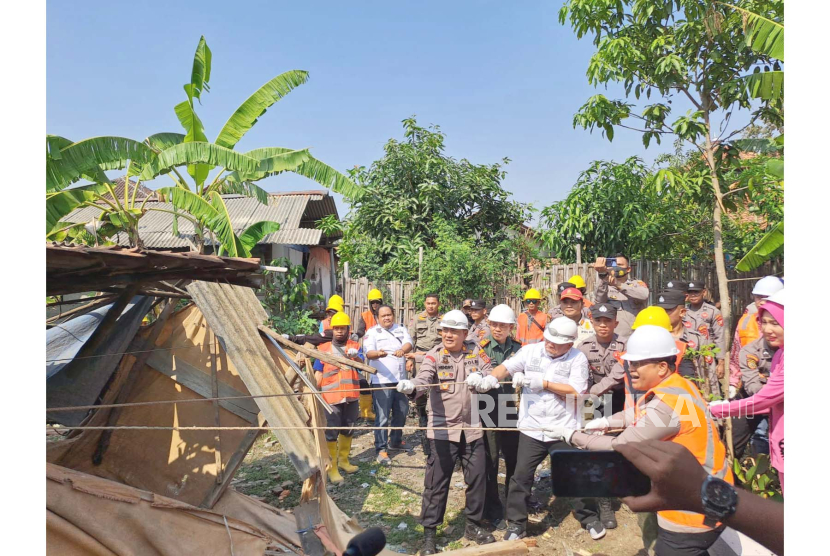 Kapolres Indramayu AKBP M Fahri Siregar (kanan) ikut merobohkan rutilahu warga di Desa Rajasinga, Kecamatan Terisi, Kabupaten Indramayu, Rabu (9/8/2023), untuk kemudian dilakukan pembangunan.