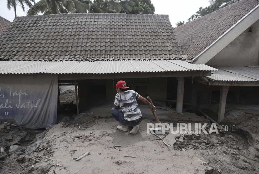 Seorang pria memeriksa rumahnya yang terkubur di kawasan yang terkena letusan Gunung Semeru di Kabupaten Lumajang, Provinsi Jawa Timur, Indonesia,5 Desember 2021. 