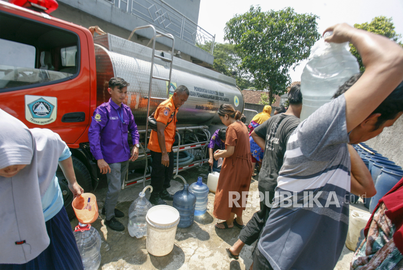 Petugas Badan Penanggulangan Bencana Daerah (BPBD) mendistribusikan air bersih kepada warga di Desa Sukahati, Citeureup, Kabupaten Bogor, Jawa Barat, Rabu (9/8/2023). BPBD Kabupaten Bogor telah menyalurkan 225.000 liter air bersih kepada warga Kabupaten Bogor yang terdampak kekeringan pada musim kemarau.  