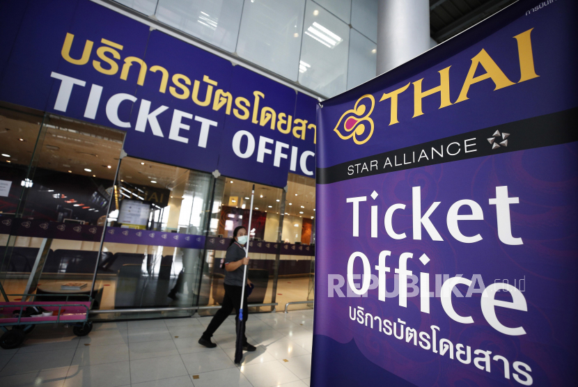 Seorang petugas kebersihan melintas di depan kantor tiket Thai Airways di bandara Internasional Suvarnabhumi, Bangkok, Thailand, Jumat (15/5).  Thailand tidak akan memberlakukan tindakan karantina yang lebih ketat bagi orang-orang yang tiba dari China