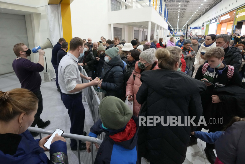 Karyawan, kiri, meminta orang untuk pergi saat toko IKEA tutup di pinggiran St. Petersburg, Rusia, Kamis, 3 Maret 2022. Komisi pemerintah Rusia telah menyetujui penjualan pabrik pembuat furnitur Swedia IKEA di Rusia kepada dua pembeli lokal. 