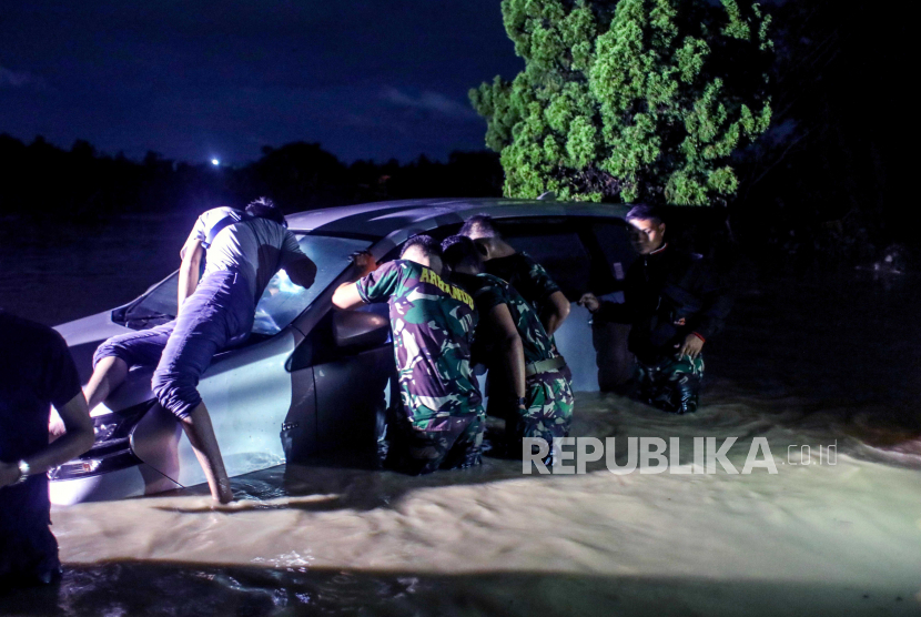 Tim penyelamat memeriksa kendaraan untuk orang-orang setelah banjir bandang di kawasan pemukiman di Medan, Sumatera Utara, Indonesia, 04 Desember 2020. Banjir tersebut diakibatkan oleh hujan lebat di daerah tersebut.