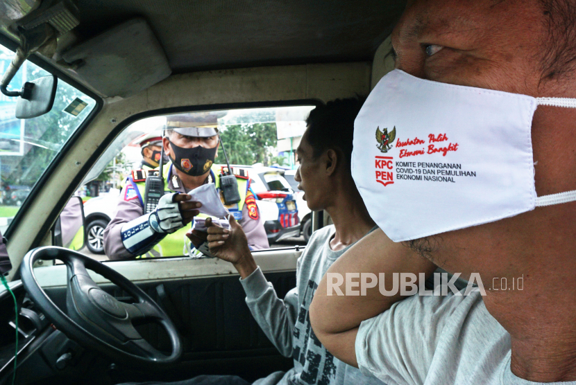 Anggota Satlantas Polres Karawang membagikan masker saat Operasi Keselamatan Lodaya 2022 di Karawang, Jawa Barat, Selasa (1/3/2022). Kasus Covid-19 di Karawang meningkat dari 43 orang menjadi 4.710 orang.
