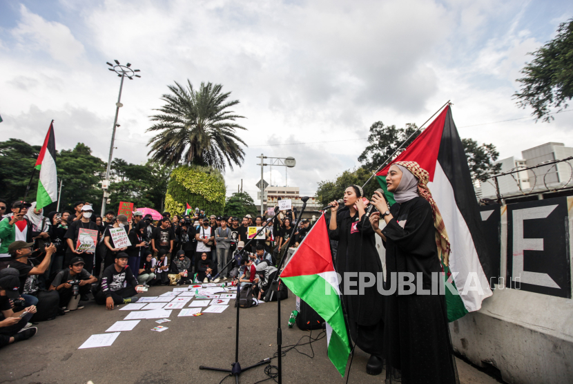 Aktris Bella Fawzi (kedua kanan) dan Penyanyi Chiki Fawzi (kanan) bernyanyi saat aksi solidaritas untuk Palestina di depan Kedutaan Besar Amerika untuk Indonesia, Jakarta, Jumat (19/4/2024). Aksi yang digagas oleh para seniman yang mengatasnamakan Koalisi Musisi untuk Gaza dan KontraS tersebut untuk memberikan wadah bagi anak muda bersuara dan menuntut agar genosida di Palestina segera dihentikan.
