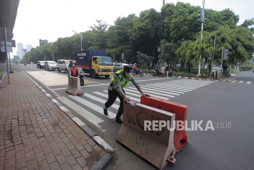 Aparat membuka pembatas jalan penyekatan di kawasan Jalan Fatmawati, Jakarta Selatan, Rabu (11/8/2021). Dinas Bina Marga DKI akan menebang sebagian pohon untuk pelebaran Jalan Fatmawati.