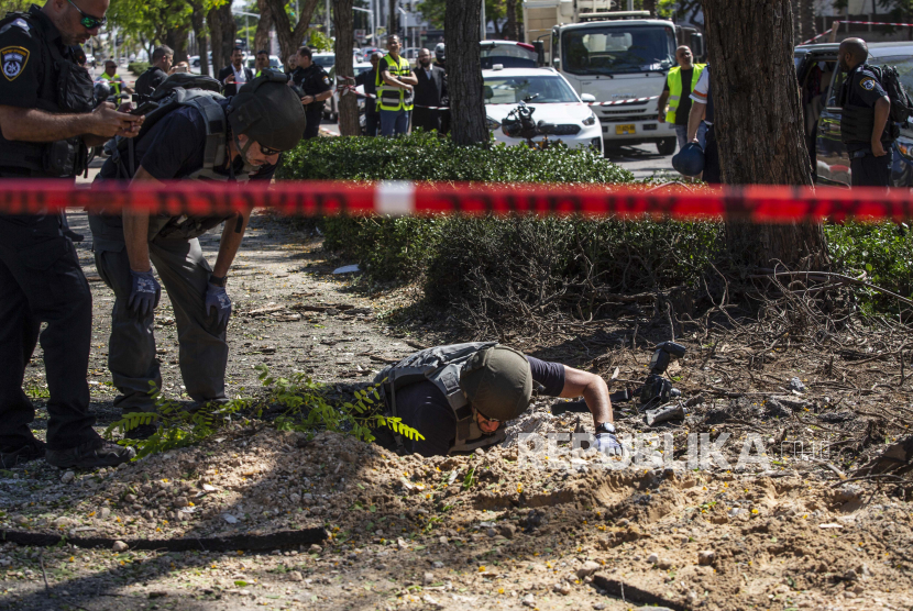  Satuan penjinak bom Israel memeriksa lokasi tempat sebuah roket yang ditembakkan dari Jalur Gaza menghantam trotoar, di Ashdod, Israel, Rabu, 19 Mei 2021.