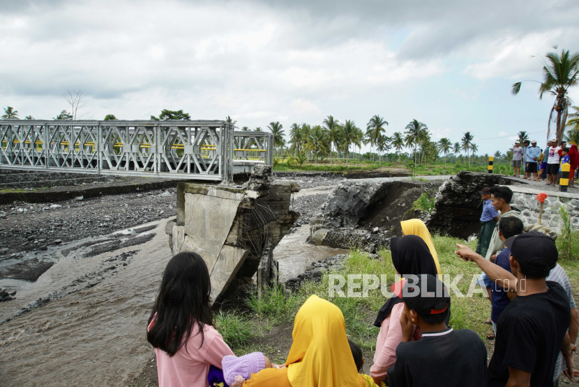 Warga mengamati kondisi Jembatan Mujur II yang rusak akibat diterang banjir lahar dingin Gunung Semeru di Kabupaten Lumajang, Jawa Timur, Jumat (19/4/2024).