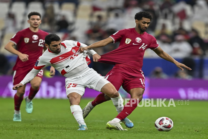 Homam Ahmed (kanan) dari Qatar berebut bola melawan Hasan Sour dari Lebanon pada laga pembuka Piala Asia AFC 2023 antara Qatar dan Lebanon di Lusail, Qatar, (12/1/2024).