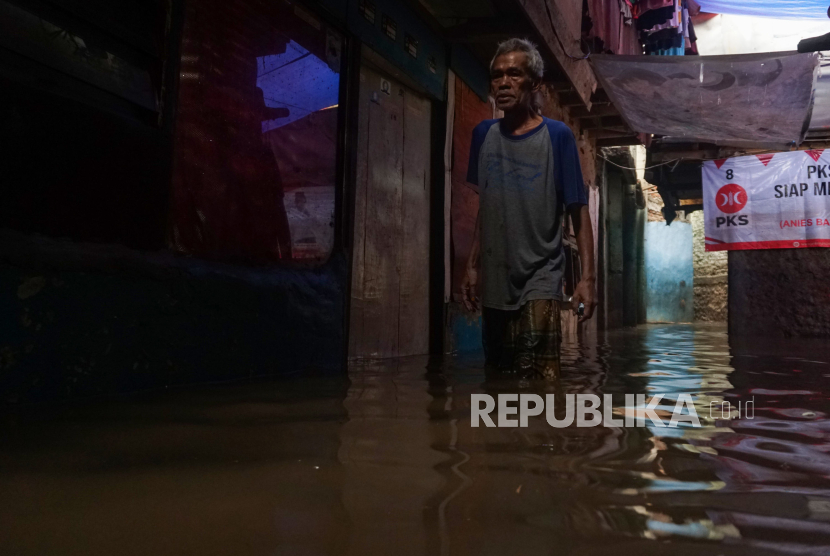 Warga menerobos banjir yang merendam rumah di Kampung Melayu, Jakarta, Ahad (5/11/2023). Soal Jakarta yang masih banjir, Pj Gubernur Heru Budi sebut masih mengeruk kali.