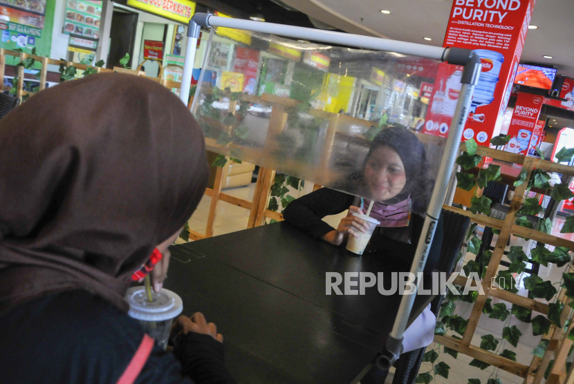 Pengunjung menikmati sajian di restoran mal Bekasi Cyber Park , Jawa Barat, Ahad (7/6/2020). Sejumlah tempat makan mulai menerapkan protokol kesehatan untuk pengunjung yang makan di tempat guna mencegah penyebaran wabah COVID-19