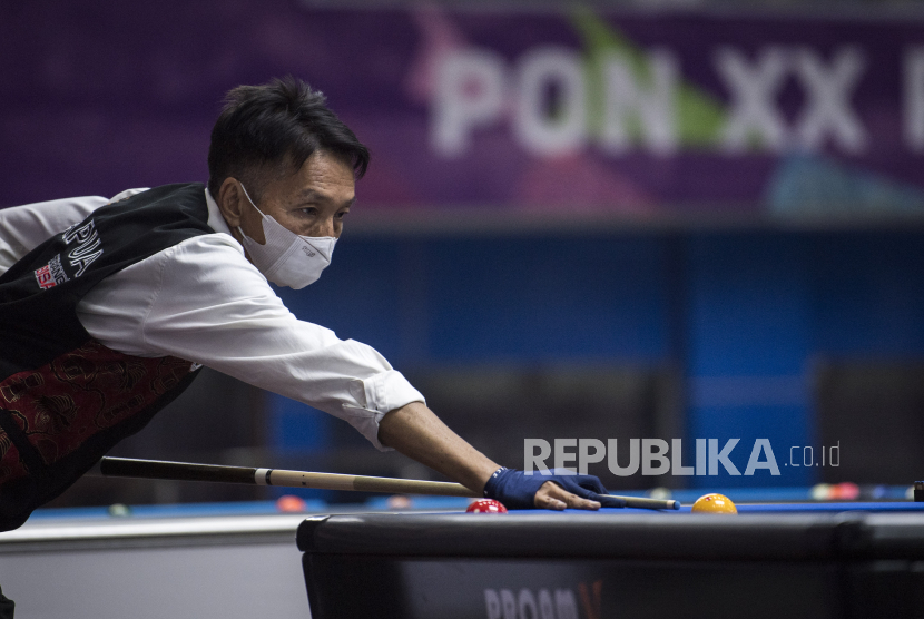 Atlet biliar Papua James Lengkang membidik untuk memasukkan bola saat bertanding babak final kategori One Cushion Single PON Papua di Gor Biliar SP 5, Kabupaten Mimika, Papua, Selasa (5/10/2021). James Lengkang berhasil meraih medeli emas pada kategori tersebut. 