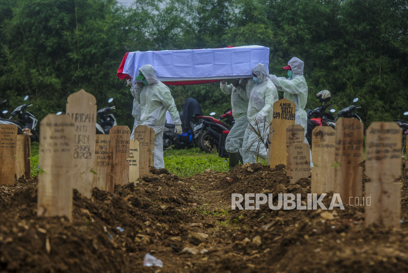 Sejumlah petugas membawa peti jenazah pasien Covid-19 di TPU Srengseng Sawah, Jagakarsa, Jakarta, Jumat (15/1). 