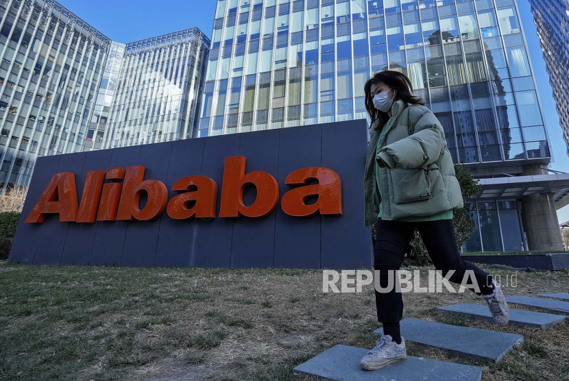  Seorang wanita mengenakan masker berjalan melewati kantor perusahaan e-commerce China Alibaba di Beijing. Alibaba dan ByteDance (pemilik TikTok) dan Tencent telah berbagi detail algoritma mereka dengan regulator China. Ilustrasi.