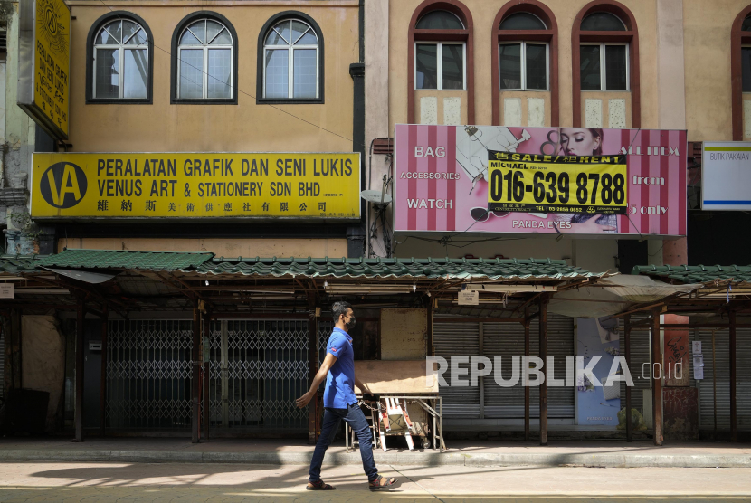 Seorang pria mengenakan masker saat melewati toko-toko yang tutup di Kuala Lumpur, Malaysia, Senin (28/6). Meningkatnya lonjakan kasus Covid-19 dan munculnya varian Delta yang memiliki tingkat penularan yang lebih berbahaya membuat sejumlah negara kembali memberlakukan lockdown. Perdana Menteri Muhyiddin Yassin mengatakan akan tetap memberlakukan lockdown kecuali kasus baru setiap hari turun di bawah 4.000, tingkat vaksinasi mencapai 10?n permintaan untuk perawatan intensif di rumah sakit berkurang. (AP Photo/Vincent Thian)Putra M. Akbar