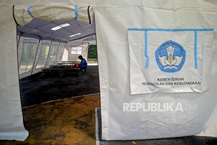 Petugas kebersihan merapikan velbed yang berada di dalam tenda darurat di Halaman SDN 02 Cideng, Jakarta, Selasa (29/6). RSUD Tarakan mendirikan tenda darurat guna mengantisipasi lonjakan kasus covid-19 dihalaman SDN 02 Cideng yang berada tepat di sebelah RSUD Tarakan.Prayogi/Republika.