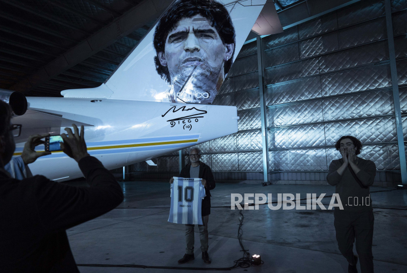 Seorang pria berpose di sebelah pesawat yang didedikasikan untuk mendiang legenda sepak bola Diego Maradona, di sebuah pangkalan militer di Moron, di pinggiran Buenos Aires, Argentina, Rabu, 25 Mei 2022. 