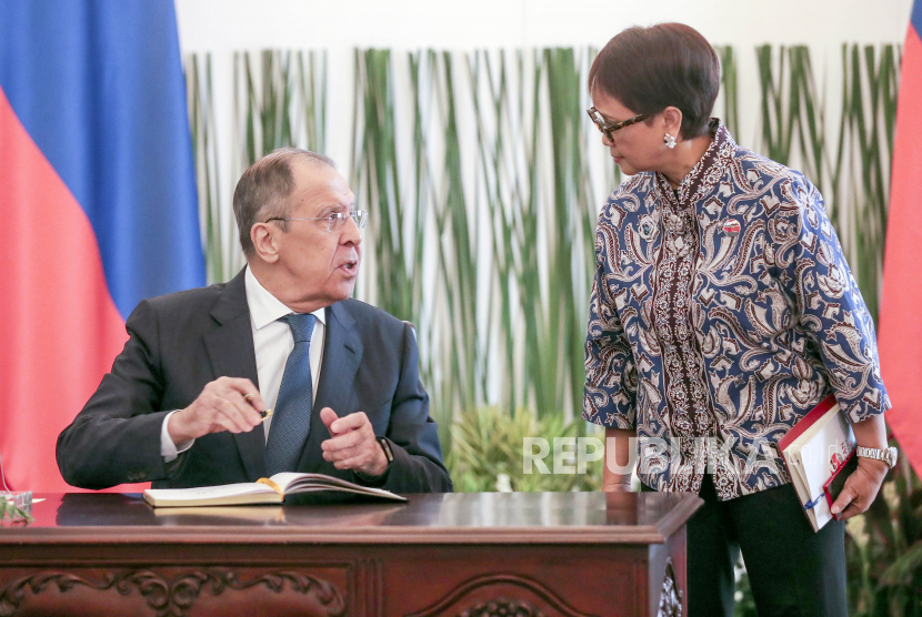   Menlu Rusia Sergei Lavrov (kiri) berbicara dengan Menlu Indonesia Retno Marsudi setibanya untuk pertemuan trilateral antara Indonesia, Rusia dan China.