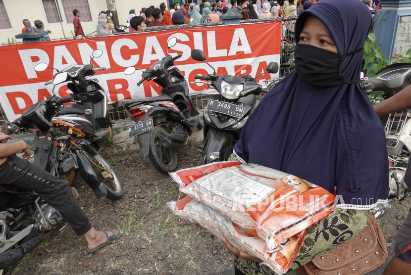 Warga mengambil beras bantuan dari Bulog bagi keluarga penerima bantuan sosial tunai (BST) dan program keluarga harapan (PKH), di Banjarnegara, Jawa Tengah, beberapa waktu lalu..