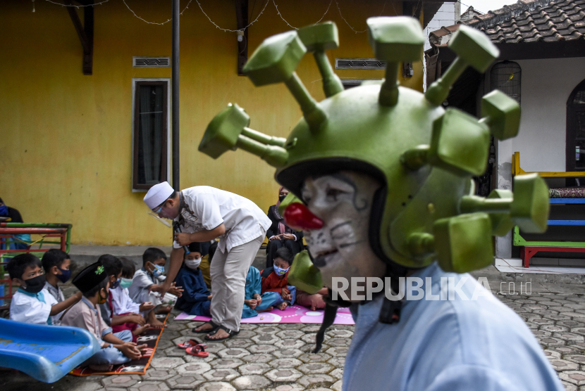 Anggota Badut Nyentrik Cimahi Bandung Sauyunan (Necis) memberikan hand sanitizer kepada anak saat pesantren Ramadhan bersama badut di Raudhatul Atfal (RA) AL Hidayah, Padalarang, Kabupaten Bandung Barat, Selasa (4/5). Pemerintah hari ini mengumumkan bahwa varian baru corona B1617, B117 dan B1351 telah masuk ke Indonesia. (ilustrasi)