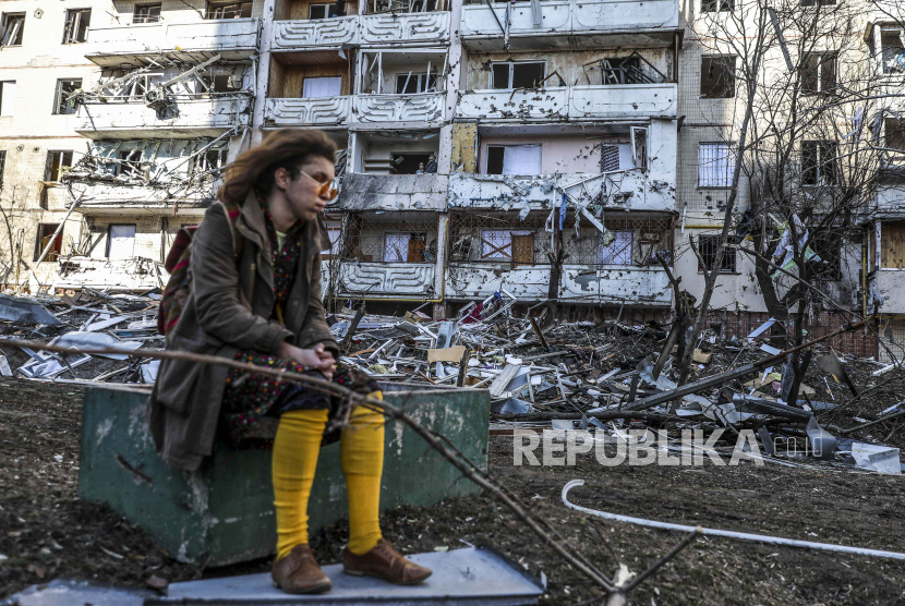  Seorang wanita berdiri di dekat puing-puing sebuah bangunan yang rusak akibat penembakan di Kyiv, Ukraina, 15 Maret 2022. Pada 24 Februari, pasukan Rusia telah memasuki wilayah Ukraina dalam apa yang dinyatakan oleh presiden Rusia sebagai 