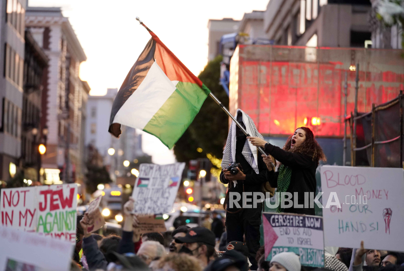 Para pengunjuk rasa berbaris dan mengibarkan bendera menentang perang Israel-Hamas bersamaan dengan KTT APEC yang berlangsung Selasa, 14 November 2023, di San Francisco.
