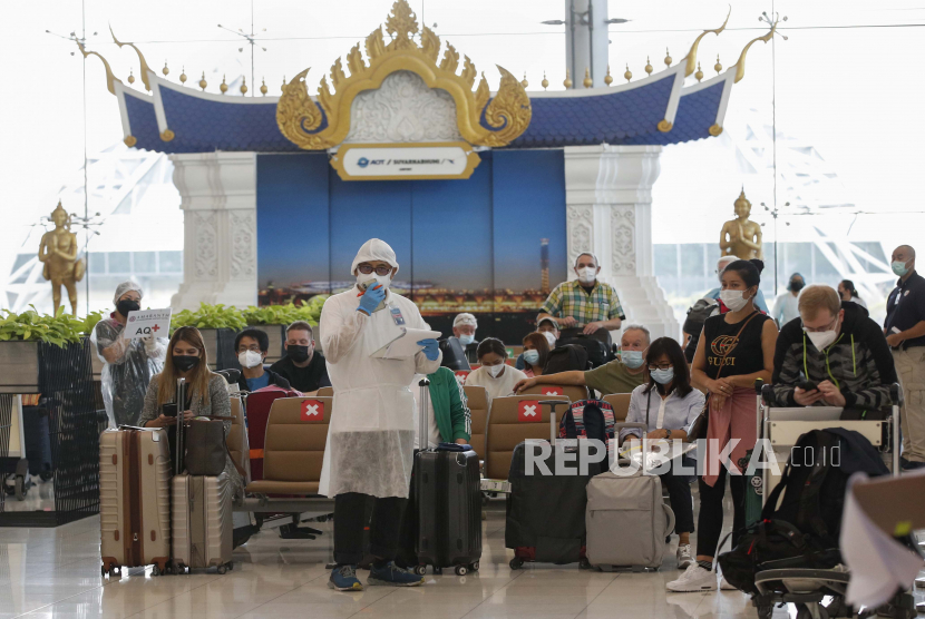 Pelancong internasional menunggu protokol pemeriksaan kesehatan dan pemeriksaan dokumen oleh pekerja hotel dengan pakaian pelindung selama hari pertama pembukaan kembali negara itu untuk pengunjung asing di Bandara Internasional Suvarnabhumi di Samut Prakan, Thailand, 01 November 2021. 