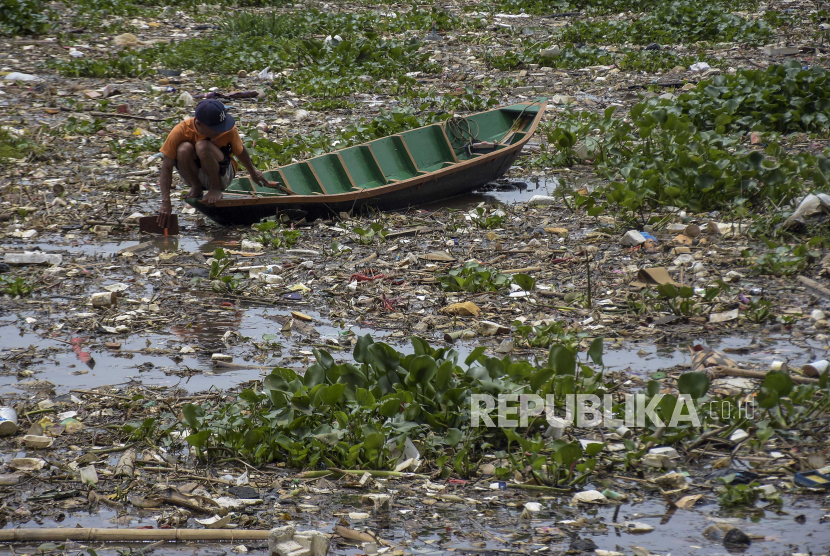 Warga menggunakan perahu untuk memilah sampah plastik di Daerah Aliran Sungai (DAS) Citarum, Cihampelas, Kabupaten Bandung Barat.