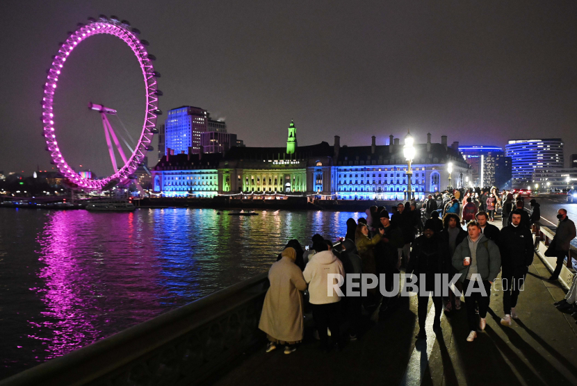  Orang-orang berkumpul di Jembatan Westminster di depan London Eye untuk Malam Tahun Baru di London, Inggris, 31 Desember 2020. Menteri Hubungan Antar-Lembaga Pemerintah dan Kesetaraan Inggris Nadhim Zahawi mengatakan 