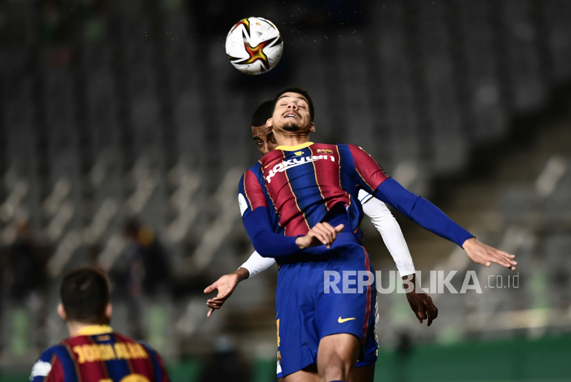 Pemain Barcelona Ronald Araujo menyundul bola.