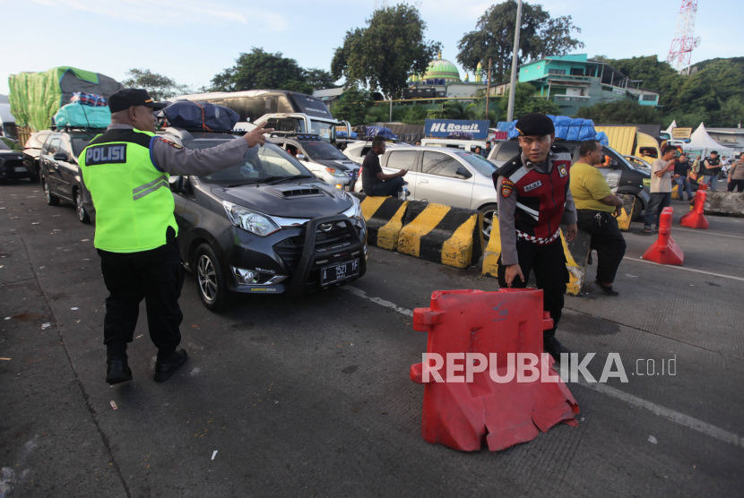 Polisi mempersilakan mobil pemudik untuk memasuki kapal ferry di Pelabuhan Merak, Cilegon, Banten, Ahad (7/4/2024). 