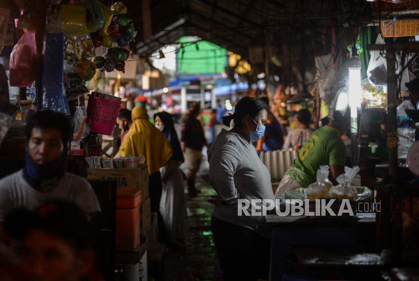 Warga menggunakan masker saat belanja di pasar tradisional Pasar Minggu, Jakarta, Kamis (17/9). Warga yang tak memiliki keperluan penting diserukan untuk tetap di rumah untuk menurunkan risiko tertular Covid-19.