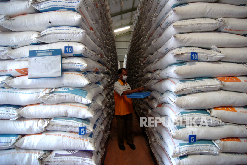 Pekerja memeriksa kualitas beras di gudang Perum Bulog. ilustrasi