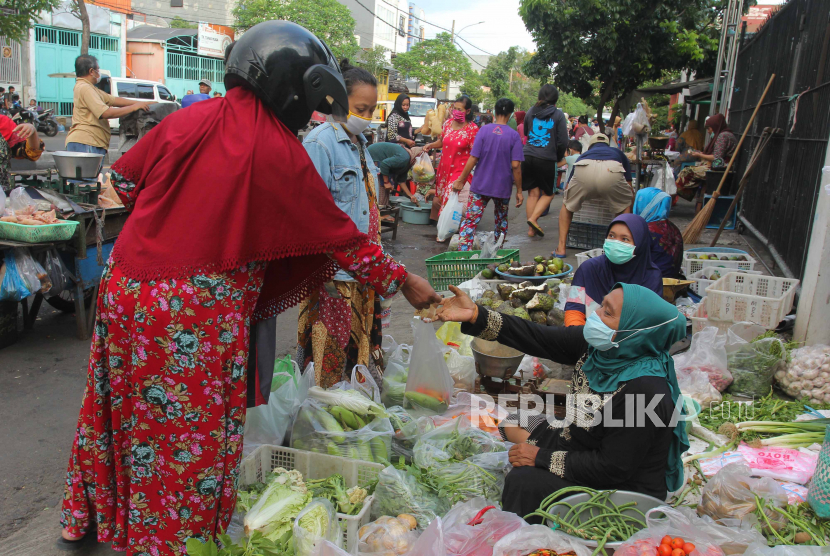 Pedagang melayani pembeli di pasar tumpah di kawasan Tembok Dukuh, Surabaya, Jawa Timur, Rabu (29/4/2020). Aktivitas pasar tumpah di kawasan itu berjalan normal di hari kedua pelaksanaan Pembatasan Sosial Berskala Besar (PSBB) di Surabaya