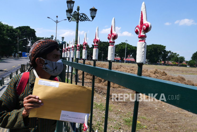 Aktivis Jogja Corruption Watch (JCW), Baharuddin Kamba membawa surat untuk Gubernur Daerah Istimewa Yogyakarta (DIY) sekaligus Raja Keraton Yogyakarta Sri Sultan HB X di depan pagar Alun-alun Utara Yogyakarta, Senin (12/7). Dalam surat itu dia meminta Sri Sultan HB X agar dapat memerintahkan jajaran beserta staffnya agar dapat memaksimalkan anggaran APBD atau Dana Keistimewaan untuk penanganan Pandemi COVID-19. Sehingga manfaatnya bisa dirasakan langsung oleh masyarakat Yogyakarta.