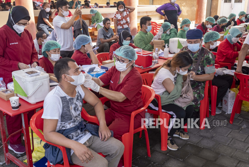  Orang-orang menerima dosis ketiga vaksin penguat COVID-19 pada acara vaksinasi di Denpasar, Bali, Indonesia, 28 Maret 2022. 