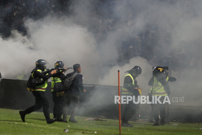 Aparat keamanan menembakkan gas air mata untuk menghalau suporter yang masuk lapangan usai pertandingan sepak bola BRI Liga 1 antara Arema melawan Persebaya di Stadion Kanjuruhan, Malang, Sabtu (1/10/2022). 
