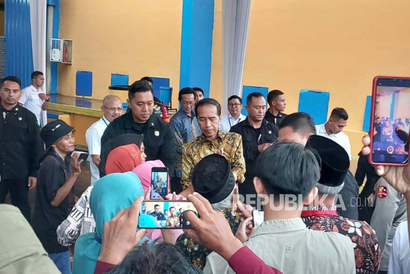 Presiden Joko Widodo (Jokowi) menyerahkan bantuan pangan kepada masyarakat di Gudang Bulog Purwomartani, Kalasan, Sleman, DIY, Senin (29/1/2024).