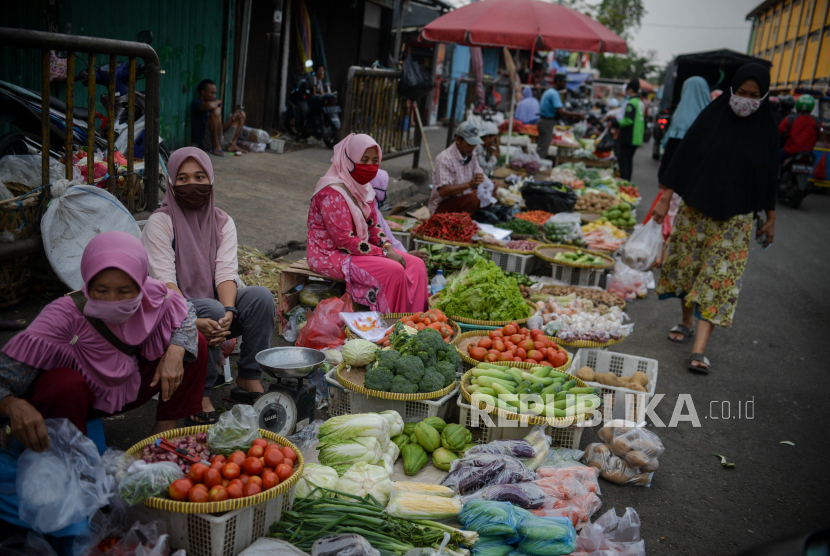 Pedagang menggunakan masker menunggu pembeli di pasar tradisional Pasar Minggu, Jakarta. ilustrasi