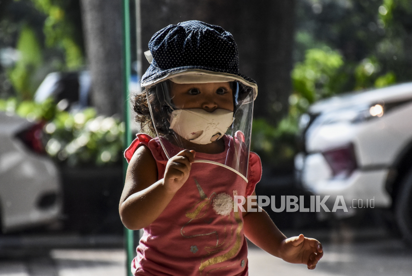 Seorang anak mengenakan masker dan pelindung wajah, Di NTT seorang anak positif Covid-19.