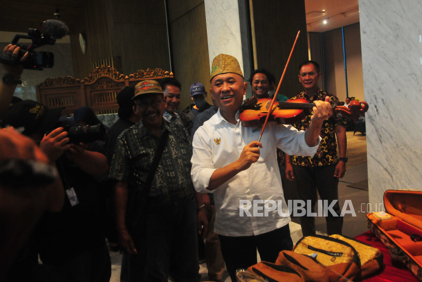 Menteri Koperasi dan UKM Teten Masduki (tengah) mengetes alat musik biola produksi salah satu Badan Usaha Milik Desa (BUMdes) saat kunjungan kerja di Kudus, Jawa Tengah, Jumat (4/11/2022).