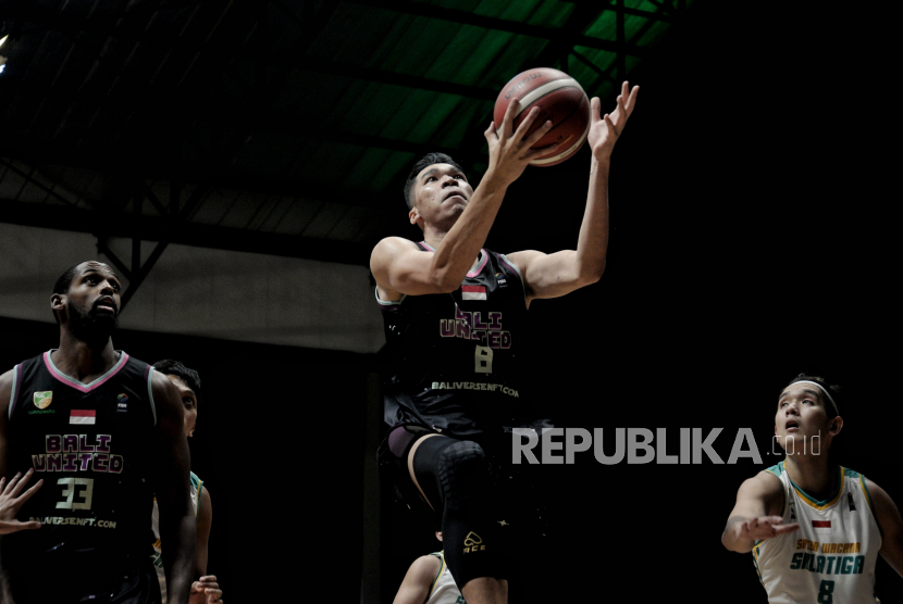 Pemain Bali United Basketball Rico Aditya Putra melakukan lay up saat pertandingan lawan Satya Wacana Salatiga  dalam pertandingan Seri 1 Jakarta Indonesian Basketball League (IBL) 2022 di Hall Basket Senayan, Kompleks Gelora Bung Karno (GBK), Senayan.