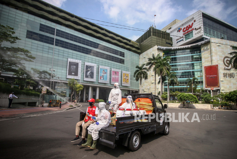 Petugas PMI Jakarta Pusat melakukan penyemprotan cairan disinfektan di depan mal Grand Indonesia, Jakarta, Ahad (31/5/2020). Penyemprotan tersebut untuk menekan dan mencegah penyebaran COVID-19 secara berkelanjutan