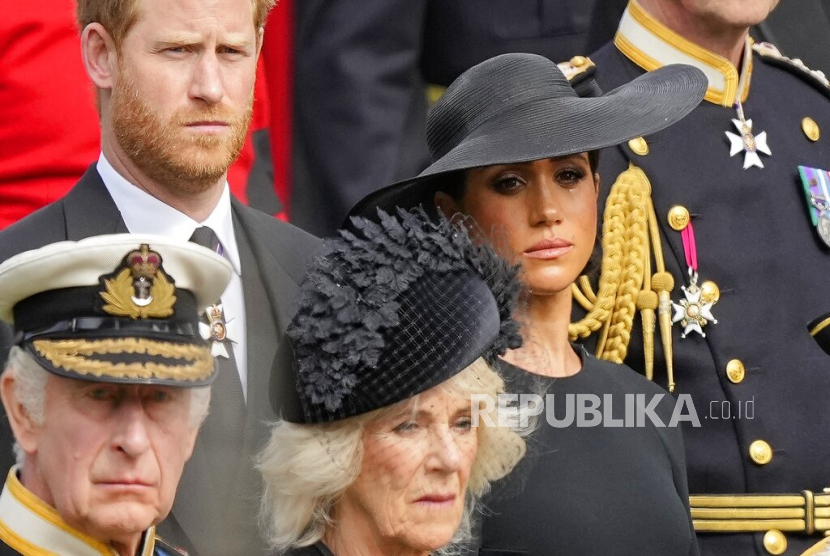  FILE - Raja Inggris Charles III (dari kiri bawah) Camilla, Permaisuri, Pangeran Harry dan Meghan, Duchess of Sussex menyaksikan peti mati Ratu Elizabeth II ditempatkan di mobil jenazah setelah upacara pemakaman kenegaraan di Westminster Abbey di pusat kota London, Senin 19 September 2022. 