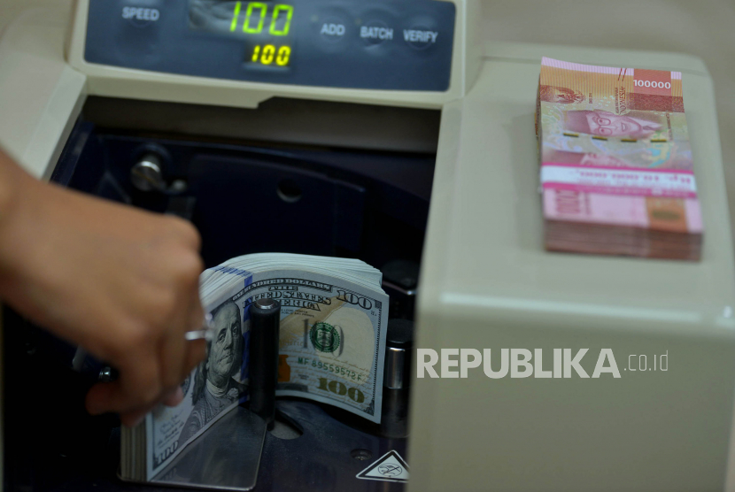 Petugas menghitung uang rupiah dan dolar AS di salah satu gerai penukaran mata uang asing di Jakarta, Kamis (29/9/2022). Rupiah pada Kamis (4/5/2023) pagi dibuka meningkat 107 poin atau 0,73 persen ke posisi Rp 14.585 per dolar AS.