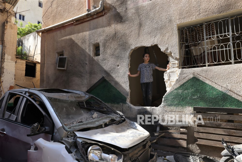 Seorang anak melihat keluar dari dinding rumah yang rusak, setelah penyerbuan tentara Israel di  Tepi Barat, 5 Juli 2023.