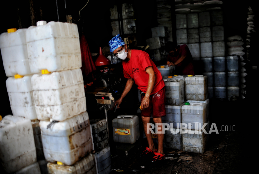 Pekerja mengisi minyak ke jerigen di agen minyak curah di kawasan Kebayoran Lama, Jakarta Selatan, Kamis (26/5/2022). Pemerintah melalui kementerian Perindustrian berencana akan menghentikan program subsidi minyak goreng curah pada 31 Mei 2022 mendatang. Republika/Thoudy Badai