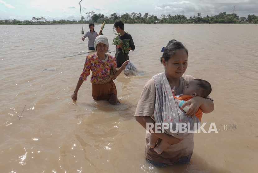 Sejumlah warga korban banjir meninggalkan lokasi pengungsian dan memilih kembali ke rumah karena khawatir dengan keselamatan harta benda mereka di Desa Nusadadi, Sumpiuh, Banyumas, Jateng, Rabu (18/11/2020). 