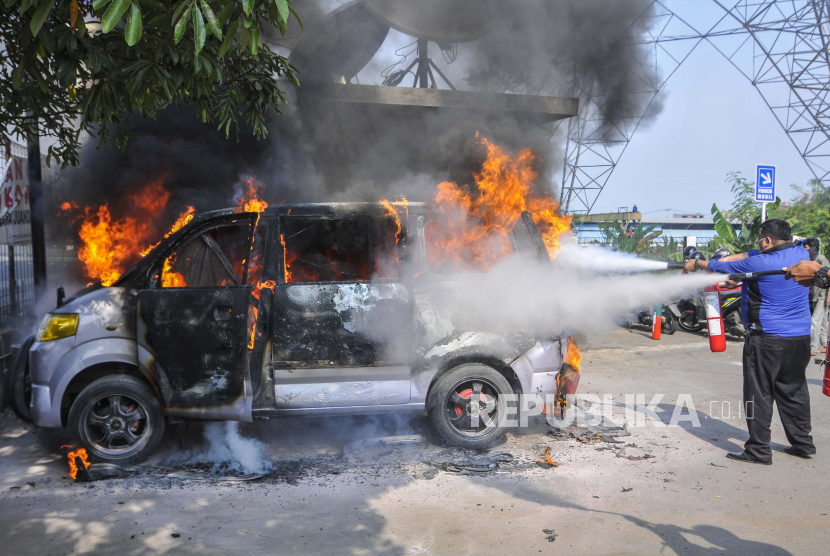 Petugas memadamkan mobil yang terbakar diduga akibat lemparan bom molotov (ilustrasi)